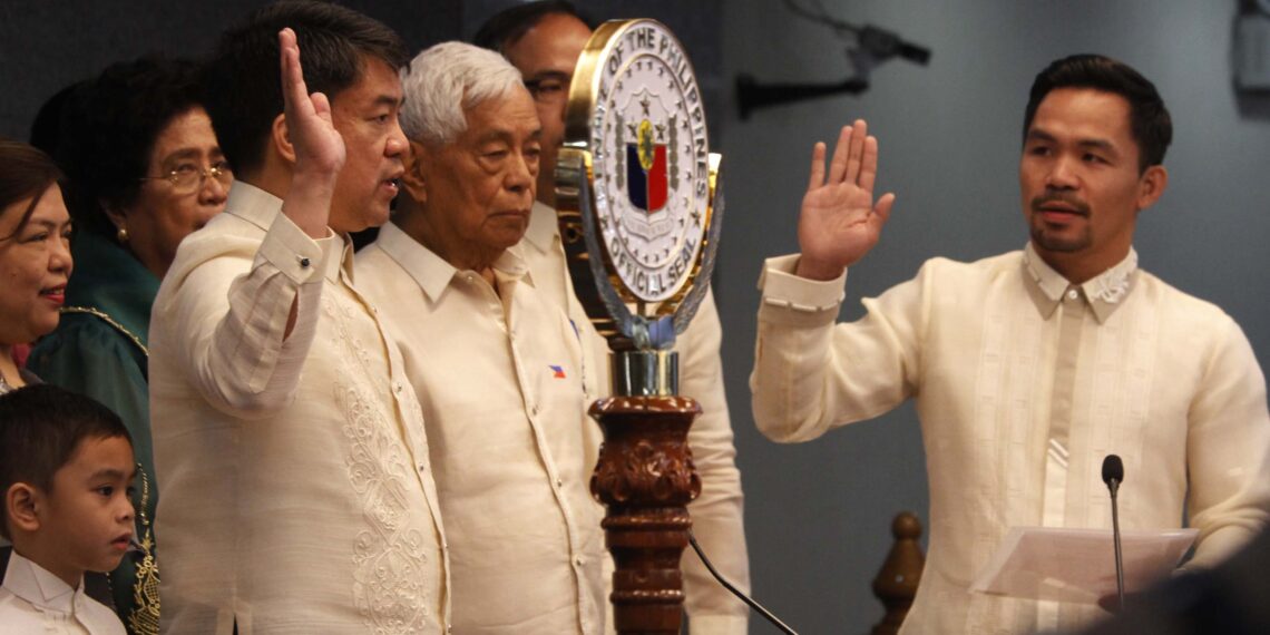 Neophyte Senator Emmanuel Pacquiao (right) administers the oath of office of newly-elected Senate President Aquilino Pimentel III during the opening of the Senate session under the 17th Congress on Monday (July 25, 2016) at the Plenary Hall of the Senate Building in Pasay City. Also in photo are immediate members of the Pimentel family, including former Senate President Aquilino "Nene" Pimentel Jr. (center). (PNA photo by Avito C. Dalan)