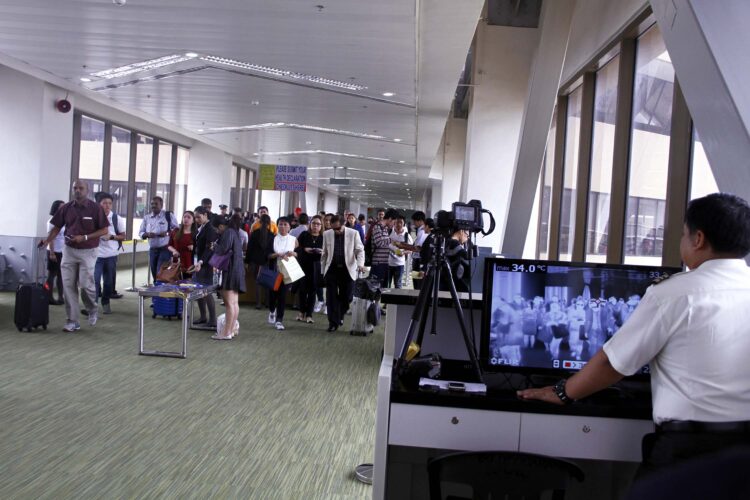 A Department of Health (DOH) quarantine officer (right) at the Ninoy Aquino International Airport (NAIA) Terminal I in Pasay City monitors arriving passengers on a thermal scanner on Monday (Aug. 29, 2016) as part of the monitoring of travelers who are symptomatic or indicating signs of Zika virus infection. (PNA photo by Jess M. Escaros Jr.)