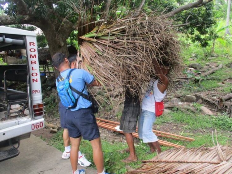 Mga Pulis at Mga opisyal ng isang Barangay sa Corcuera, nagsama-sama sa pagawa ng bahay ng isang Lola